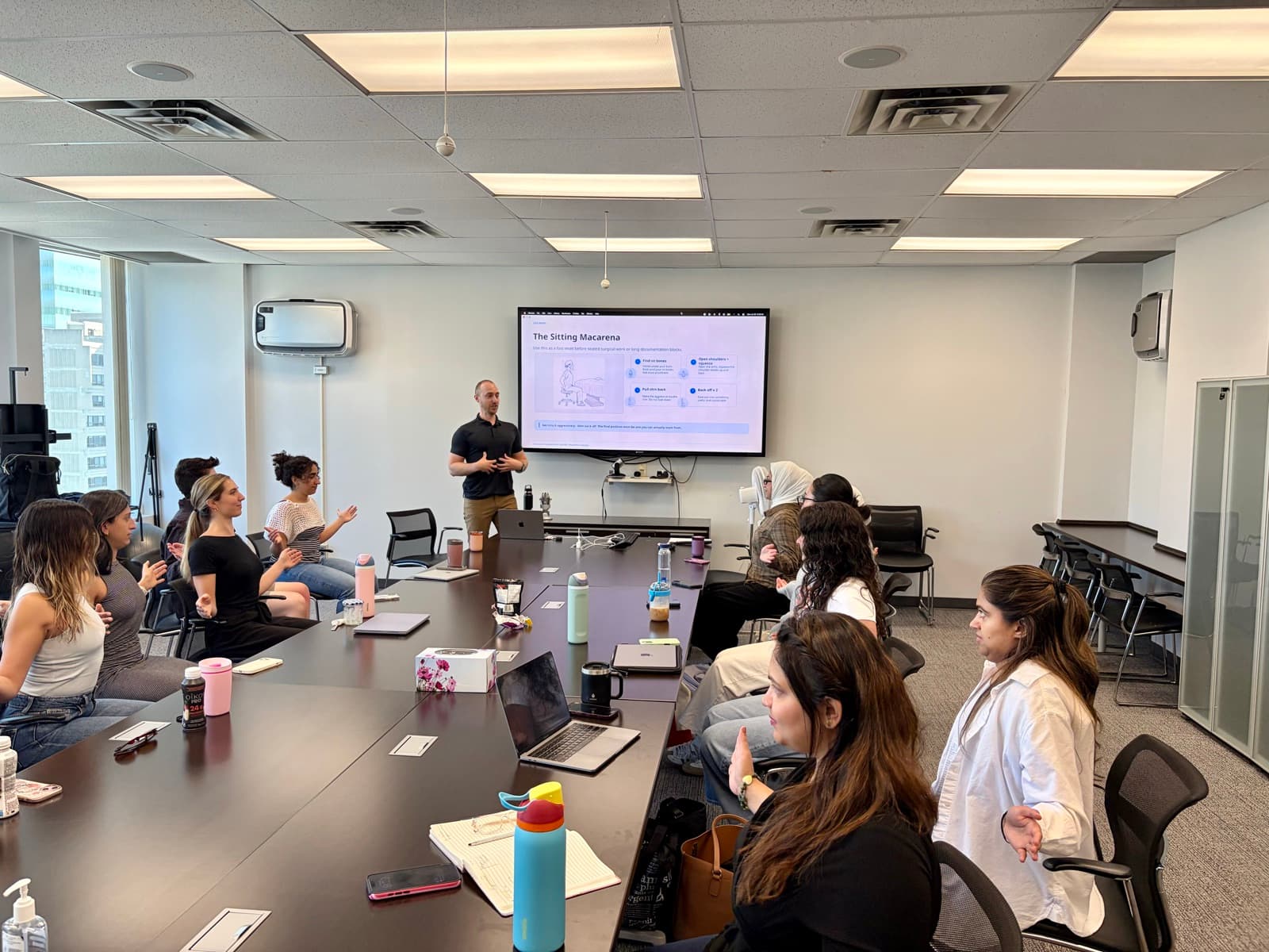 Corporate team seated around a boardroom table during a Desk Jockey Physio ergonomics seminar