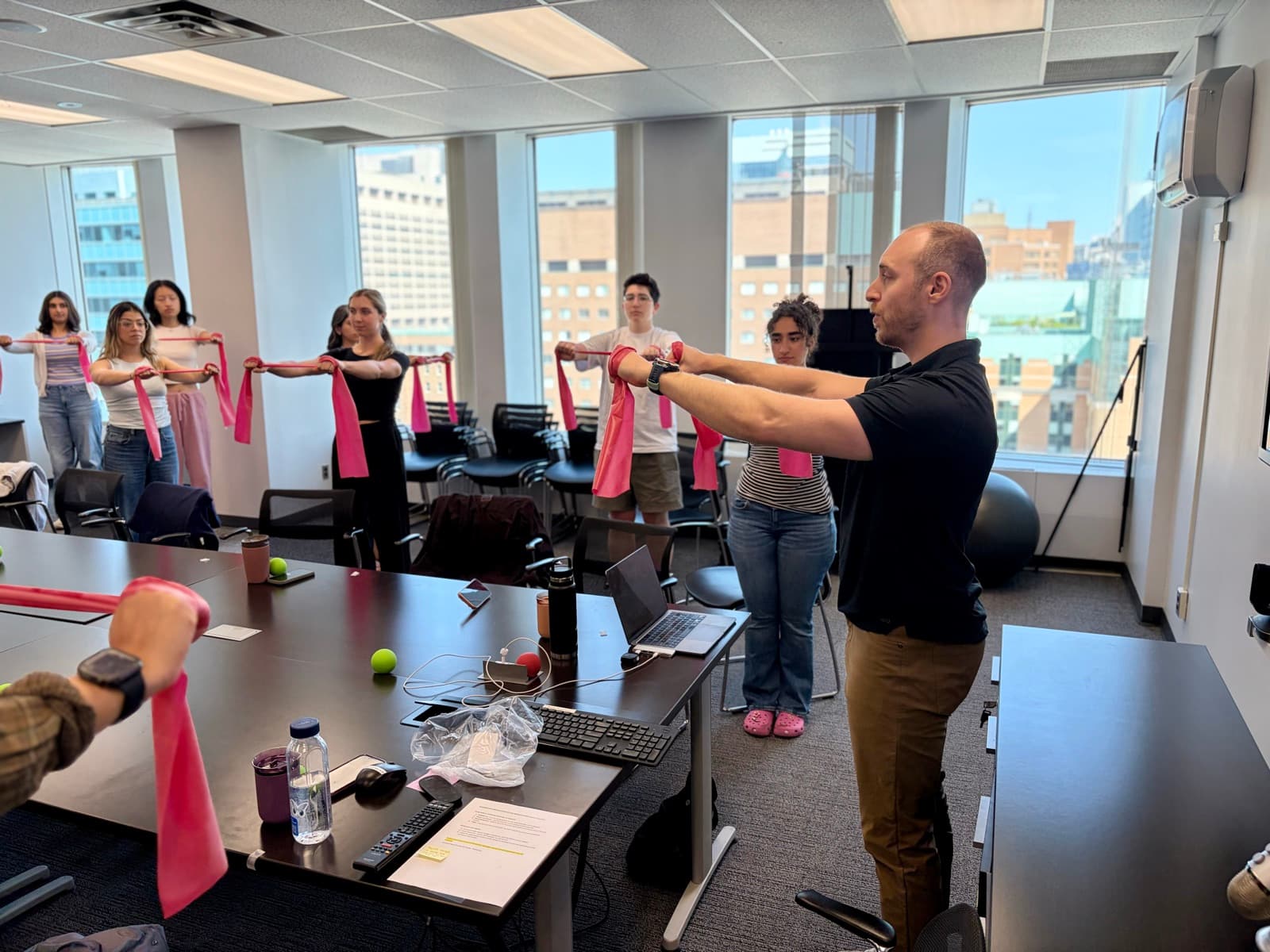 Team doing a resistance band movement break during a Desk Jockey Physio workshop